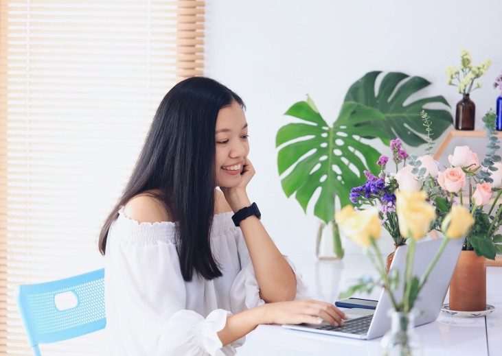 woman smiling while working on a laptop
